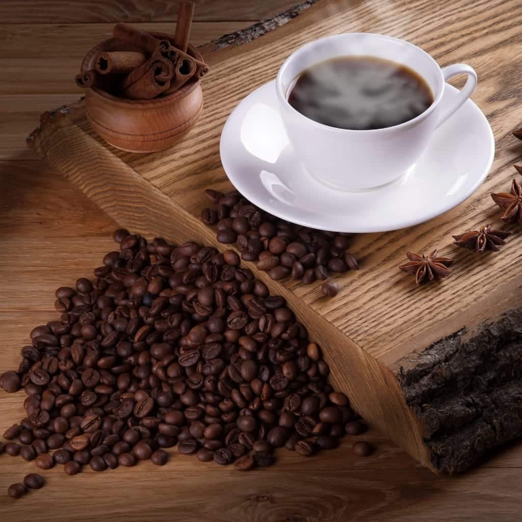 A steaming cup of freshly brewed coffee sitting on a rustic wooden table