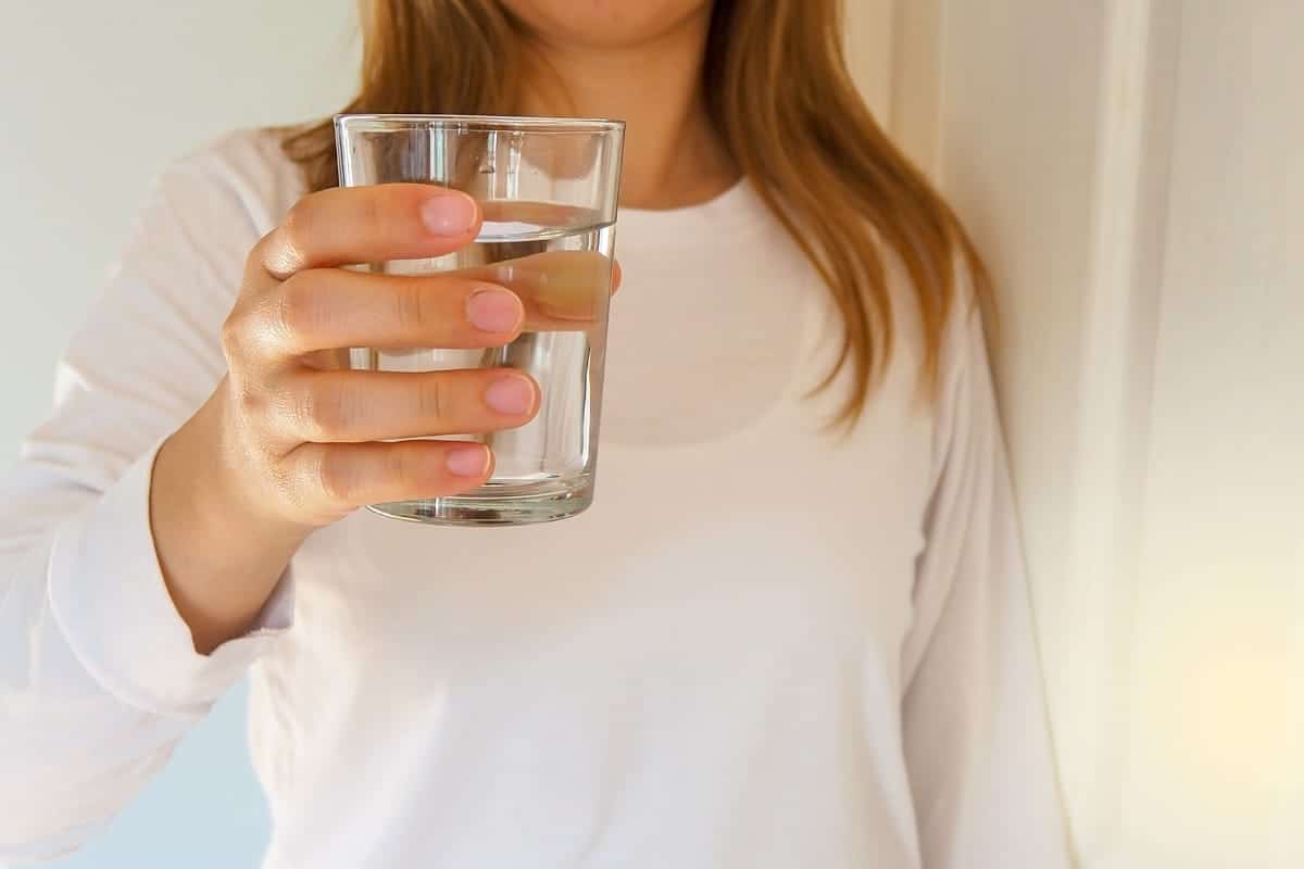 A man sipping water during a flight to prevent dehydration